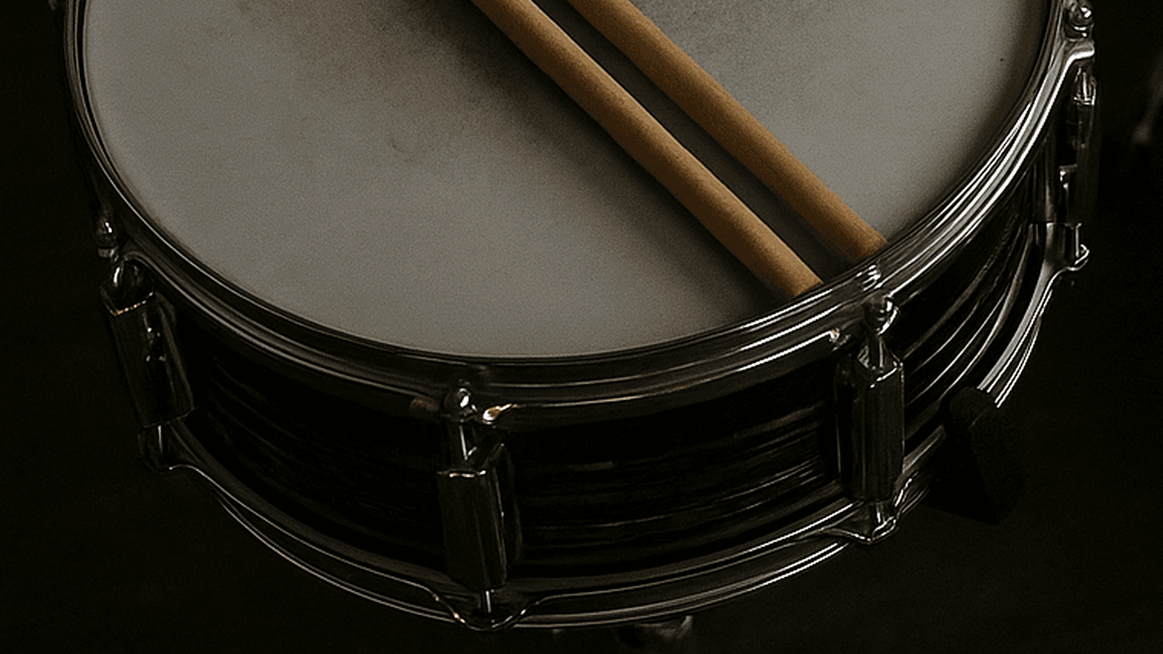 Close-up of drumsticks resting on a snare drum, representing rhythm as a focus anchor