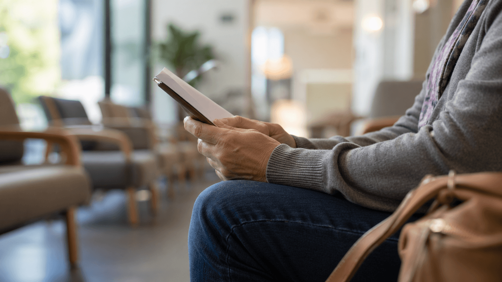 Hands holding an appointment paper in a quiet clinic waiting area during scan anxiety